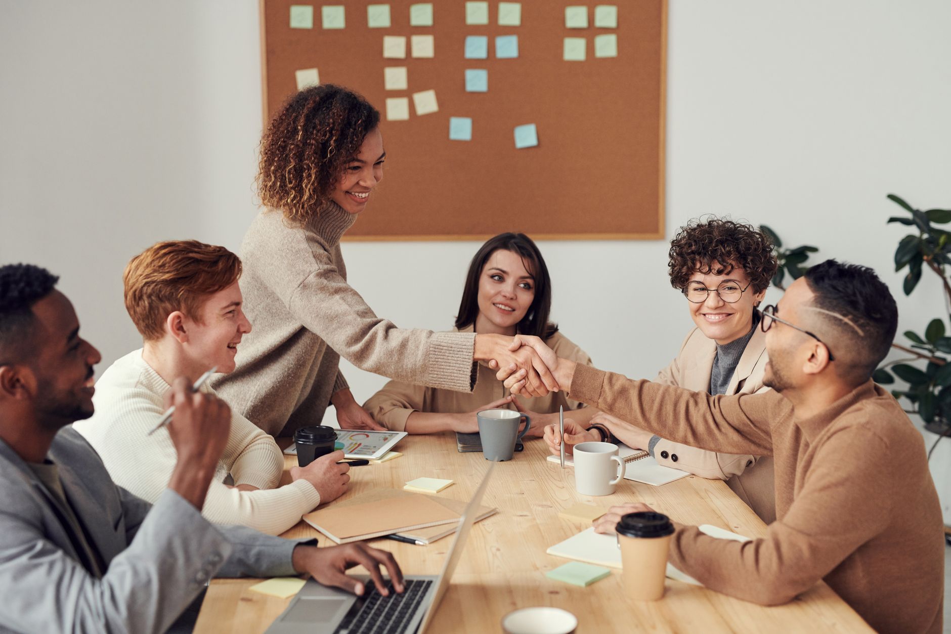 A team working together at a table, one person standing and explaining a document